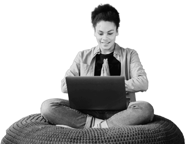 A person sitting cross-legged with a laptop, reading